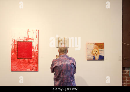 Man looking closely at display in art gallery Stock Photo