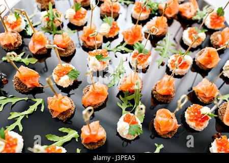 the buffet at the reception. Assortment of canapes. Banquet service. catering food, snacks with salmon and caviar. rye, wheat bread. selective focus