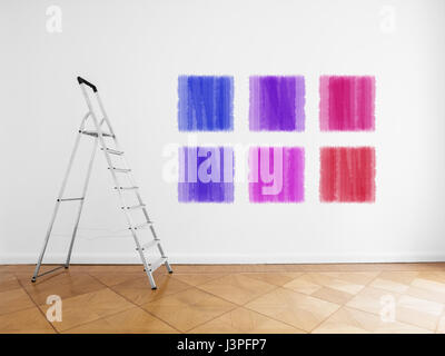 empty room with ladder and colored paint samples on wall Stock Photo