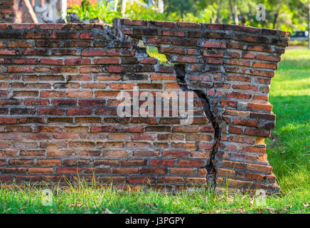 A red bricked wall with a big crack. Stock Photo