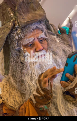 A very old man with a long beard playing with a smart phone. Stock Photo