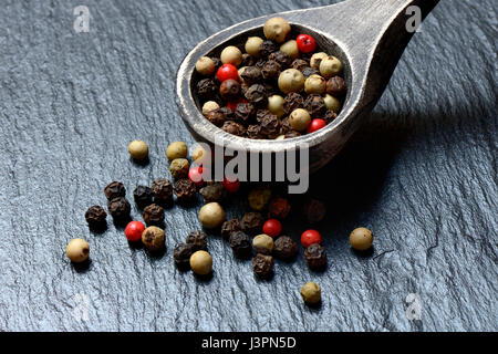 Pfefferkoerner in Holzloeffel, weisser, schwarzer, gruener und rosa Pfeffer Stock Photo