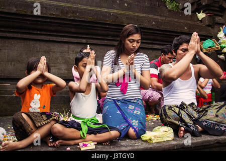 Hindu family praying in a Bali temple Tirta Empul Stock Photo