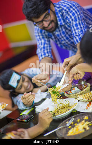 People in a restaurant laughing and eating. Stock Photo