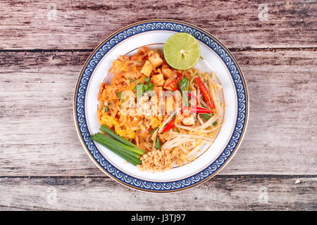 Popular Thai fried noodle with cube tofu and dried shrimp, call Pad Tai in Thai,served on Thai pattern dish. Stock Photo
