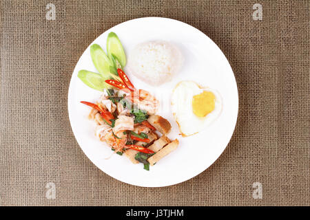 Thai food ,Jasmine rice topped stir - fried spicy basil with shrimp ,squid and crispy pork and heart shape of fried egg call Kao Pad Kra Prao Seafood. Stock Photo