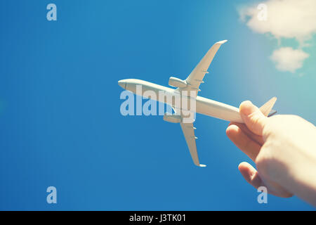 dreams of journey - hand with small airplane model against blue sky Stock Photo