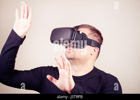 Young man using a virtual glasses on white background Stock Photo