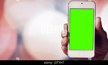 Smartphone with Green Screen on before Bokeh Background Stock Photo