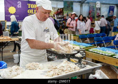 A baker weighs out portions of dough as he makes Irish soda bread farls. Stock Photo