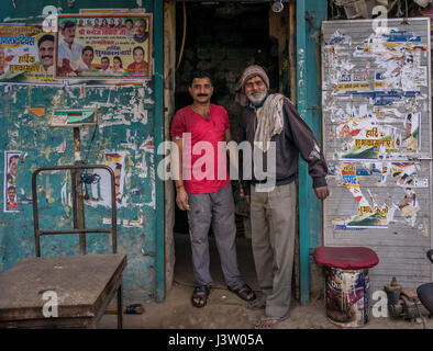 Two men standing by door in Delhi, India Stock Photo