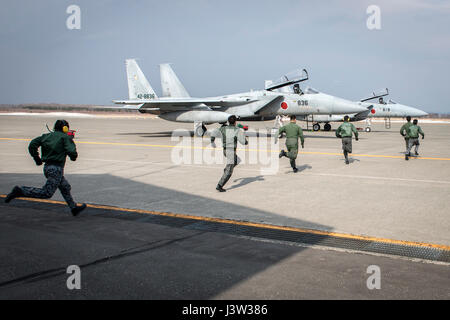 Koku-Jieitai pilots race to two Mitsubishi F-15J Eagles during a scramble demonstration as part of a 10-day U.S.-Japan Bilateral Career Training at Chitose Air Base, Japan, April 14, 2017. The scramble showcased the 2nd Air Wing’s response capability to outside threats as the installation responds to incursions into Japanese airspace every week. The F-15Js offer the Koku-Jieitai a twin-engine, all-weather air superiority fighter based on the U.S. Air Force’s McDonnell Douglas F-15 Eagle. Koku-Jieitai is the traditional term for Japan Air Self Defense Force used by the Japanese military. (U.S.  Stock Photo