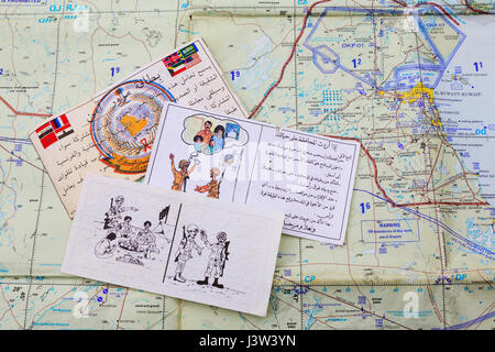 Psyops Leaflets encouraging Iraqi forces to surrender to Coallition forces during the Gulf War of 1990-1991, seen over an air map. Stock Photo