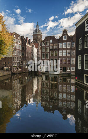 The canal houses along the junction of the canals Oudezijds Voorburgwal and Oudezijds Achterburgwal in the old center of Amsterdam Stock Photo