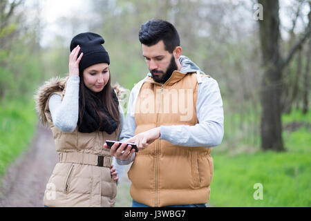 Hiker couple in the nature are lost and use GPS navigation Stock Photo