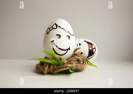 Eggs are funny muzzles. Two eggs fight for the nest. Smiles and laughter. To roll on the floor with laughter. Photo for your design Stock Photo