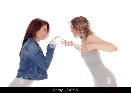 Two young woman standing opposite and fighting with words and pointing there finger, isolated for white background. Stock Photo
