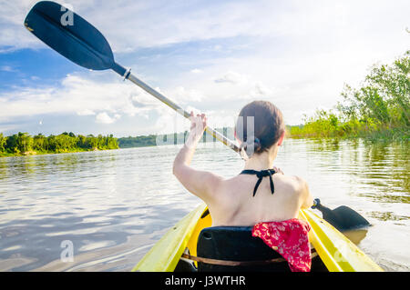 View on girl riding kayak on Amazon river by Leticia in Colombia Stock Photo