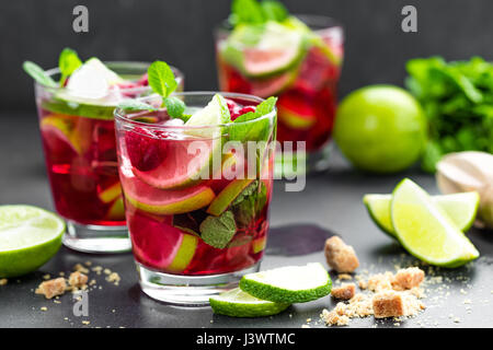 Raspberry mojito cocktail with lime, mint and ice, cold, iced refreshing drink or beverage Stock Photo