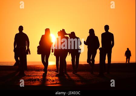 Aberystwyth  Wales Uk, Sunday 07 May 2017  People enjoying a spectacular golden sunset over the sea in Aberystwyth on the coast of west Wales   After apparently the driest winter in 20 years , the prospect of hosepipe bans over the summer has become more likely.   photo credit:  Keith Morris / Alamy Live News Stock Photo