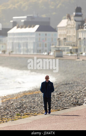 Conwy County, Wales, UK Weather, Glorious sunshine on the west coast of the UK today including North Wales. - A peson takes a stroll along the seafront promenade at the North Wales coastal town of Llandudno Credit: Stock Photo
