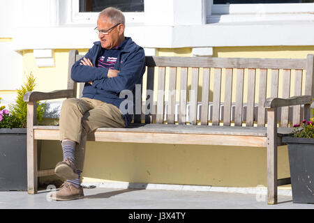 Conwy County, Wales, UK Weather, Glorious sunshine on the west coast of the UK today including North Wales. - A peson relaxing on a bench in the warm sunshine on the promenade of the North Wales coastal town of Llandudno Stock Photo