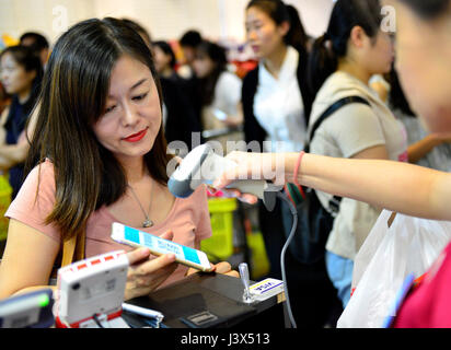 (170508) -- BEIJING, May 8, 2017 (Xinhua) -- A customer pays with Alipay at a department store in Singapore, Dec. 11, 2016. It is a common thing in China to take no cash and pay with a smartphone, which is installed with China's Alipay or Wechat apps. With a smartphone, people can pay almost everything such as shopping, repairing car, paying a taxi and registering a hospital. In many other countries, payment with Alipay and Wechat is becoming a new trend. Alipay's parent company, Ant Financial Services Group or 'Ant Financial,' has more than 200 million users in 25 countries and regions. Wecha Stock Photo