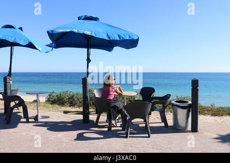 Adelaide Australia. 9th May 2017. A woman enjoying the sunshine  on a day of clear blue skies  on the beach at the coastal suburb of Brighton as temperatures stay mild during the Autumn season in Adelaide Credit: amer ghazzal/Alamy Live News Stock Photo
