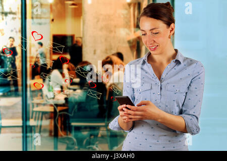 Technology, internet, communication and people concept - happy smiling young woman texting on smartphone Stock Photo