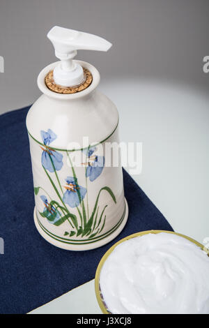 Lotion in an attractive pottery container beside a bowl of lotion Stock Photo