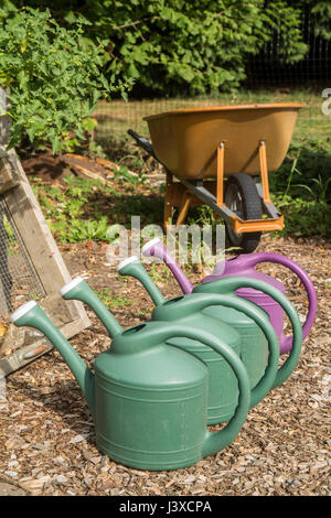 Row of plastic watering cans for hand-watering a garden in Issaquah, Washington, USA Stock Photo