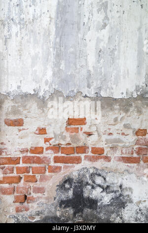 Broken, old and plastered wall revealing old brick wall. Stock Photo