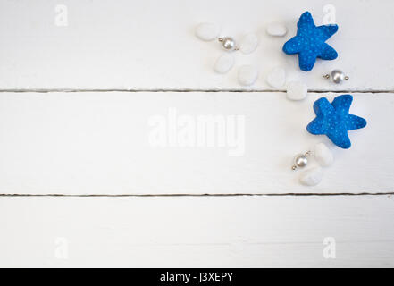 Background with white, pearl necklace pendants, beach pebbles and blue starfish on white wooden planks - concept of relaxation and luxury Stock Photo