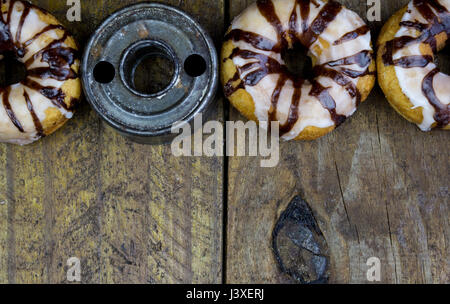Retro donut cutter with sugar frosted donuts close up on rustic wood table Stock Photo