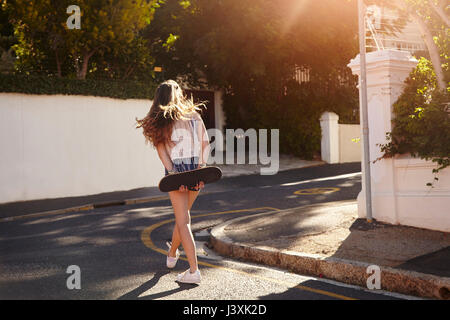 Teenage girl with skateboard in street, Cape Town, South Africa Stock Photo