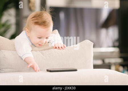 Baby looking interested in mobile phone Stock Photo