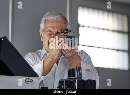 Senior man looking through camera Stock Photo