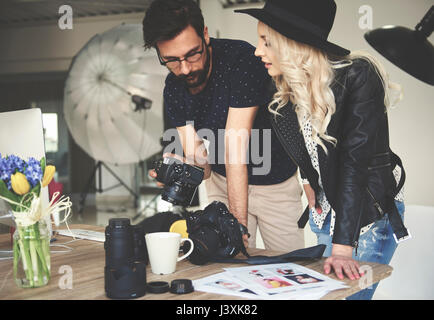Photographer and stylist reviewing photographs on photography studio camera Stock Photo