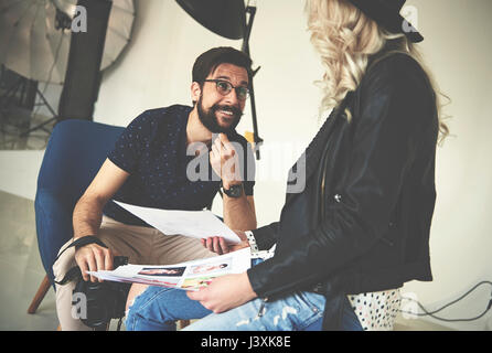 Photographer and stylist having discussion in photography studio Stock Photo