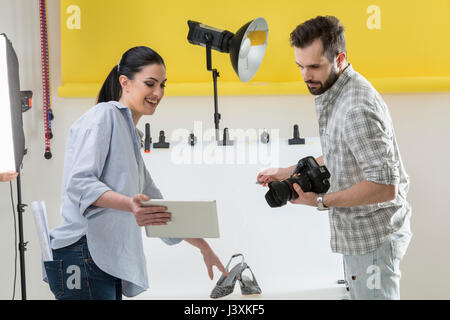 Stylist and photographer looking at digital tablet in photography studio Stock Photo