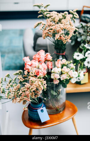 Cut flower display on coffee table in florist shop Stock Photo