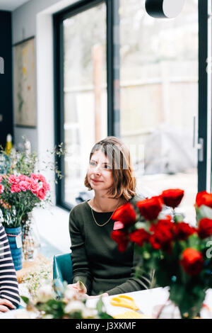 Female student florist listening at flower arranging workshop Stock Photo