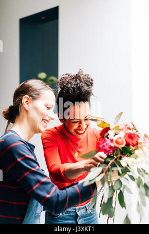 Florist and student arranging bouquet at flower arranging workshop Stock Photo