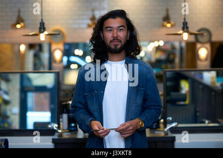 Portrait of barber holding straight razor in retro style barber shop Stock Photo