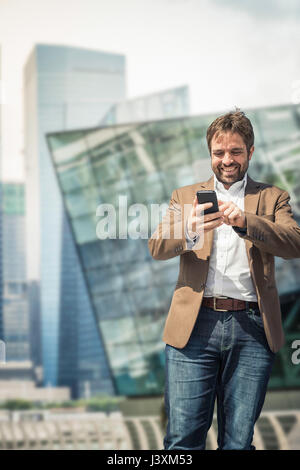 Businessman using smartphone touchscreen in city Stock Photo