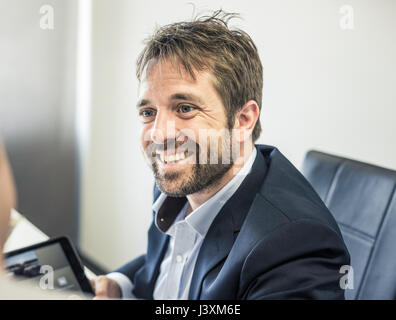 Over shoulder view of two businessmen at office desk using digital tablet Stock Photo
