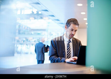 Businessman typing on laptop in office Stock Photo