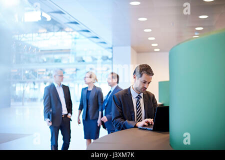 Businessman typing on laptop in office Stock Photo