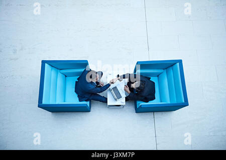 Overhead view of businessmen shaking hands in office atrium Stock Photo