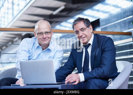 Portrait of two mature businessmen meeting on office balcony Stock Photo